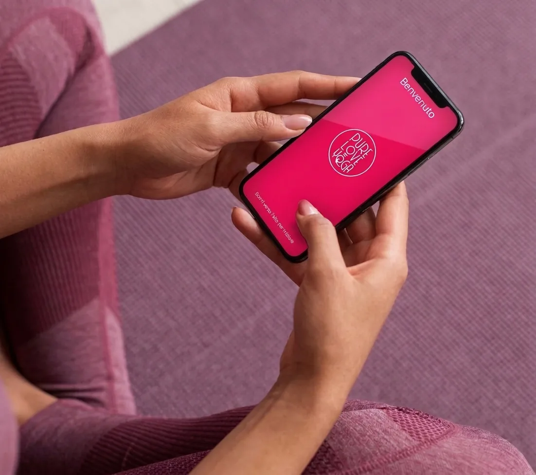 Una donna usa l'app di Pure Love Yoga dal telefono