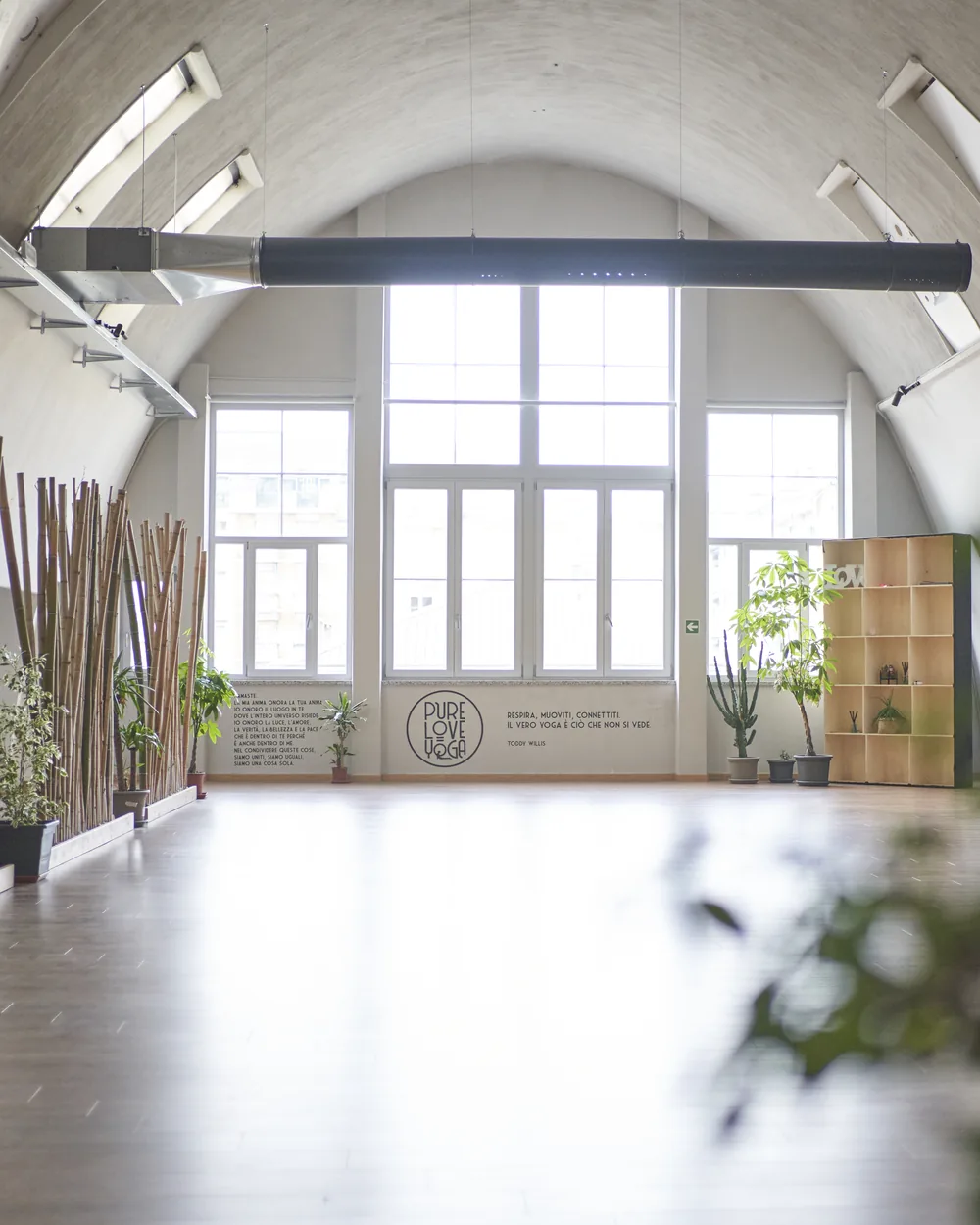 La sala grande di Via Bogetto: volta a botte bianca, grande finestra in fondo e il logo Pure Love Yoga sulla parete